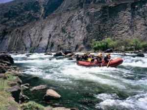 Un grupo de deportistas desciende en bote por los rápidos de un río de montaña
