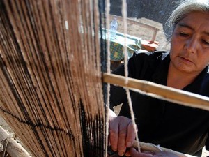Una mujer teje en telar